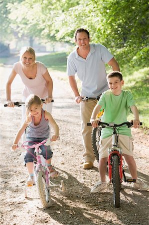simsearch:400-04402100,k - Family on bikes on path smiling Stock Photo - Budget Royalty-Free & Subscription, Code: 400-04042771