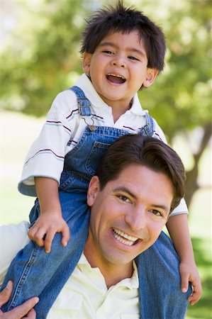 simsearch:400-04042848,k - Man giving young boy shoulder ride outdoors smiling Fotografie stock - Microstock e Abbonamento, Codice: 400-04042797