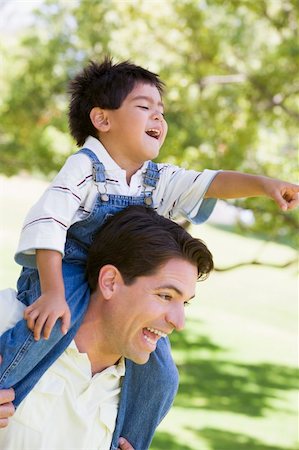 simsearch:400-04042848,k - Man giving young boy shoulder ride outdoors smiling Fotografie stock - Microstock e Abbonamento, Codice: 400-04042798