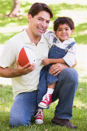 simsearch:400-04042848,k - Man and young boy outdoors with football smiling Fotografie stock - Microstock e Abbonamento, Codice: 400-04042801