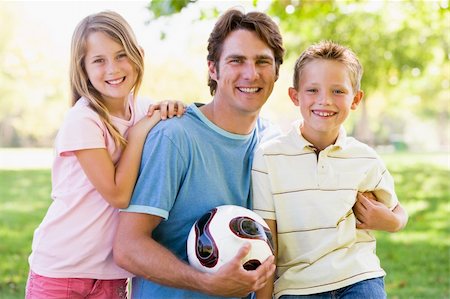 simsearch:400-04042848,k - Man and two young children outdoors holding volleyball and smili Fotografie stock - Microstock e Abbonamento, Codice: 400-04042819