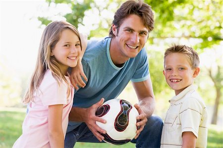 simsearch:400-04042848,k - Man and two young children outdoors holding volleyball and smili Fotografie stock - Microstock e Abbonamento, Codice: 400-04042820