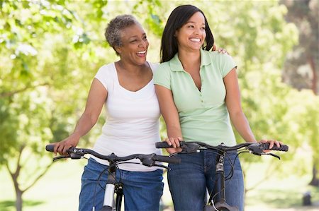 simsearch:400-04402106,k - Two women on bikes outdoors smiling Fotografie stock - Microstock e Abbonamento, Codice: 400-04042834