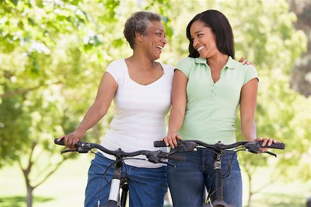 simsearch:400-04402106,k - Two women on bikes outdoors smiling Fotografie stock - Microstock e Abbonamento, Codice: 400-04042833