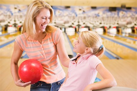 Woman and young girl in bowling alley holding ball and smiling Stock Photo - Budget Royalty-Free & Subscription, Code: 400-04042891