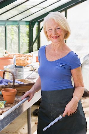 person relaxing in a greenhouse - Woman in greenhouse holding shovel and smiling Stock Photo - Budget Royalty-Free & Subscription, Code: 400-04043079