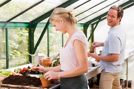 person relaxing in a greenhouse - Couple in greenhouse putting soil in pots smiling Stock Photo - Budget Royalty-Free & Subscription, Code: 400-04043107