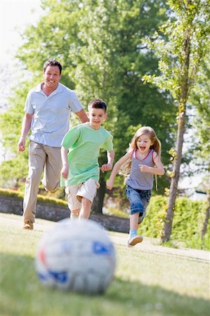 father and girl playing soccer - Man and two young children outdoors playing soccer and having fu Stock Photo - Budget Royalty-Free & Subscription, Code: 400-04043123