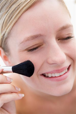 simsearch:400-04043357,k - Woman with makeup brush smiling Photographie de stock - Aubaine LD & Abonnement, Code: 400-04043345