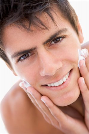 simsearch:400-04043357,k - Man putting on shaving cream smiling Photographie de stock - Aubaine LD & Abonnement, Code: 400-04043348