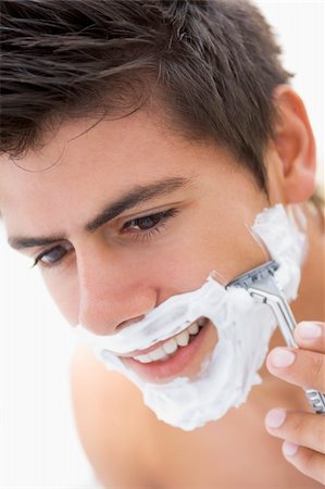 simsearch:400-04043357,k - Man shaving and smiling Photographie de stock - Aubaine LD & Abonnement, Code: 400-04043352