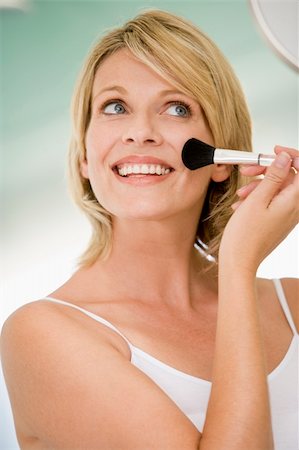 simsearch:400-04043357,k - Woman with makeup brush smiling Photographie de stock - Aubaine LD & Abonnement, Code: 400-04043400