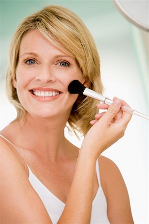 simsearch:400-04043357,k - Woman with makeup brush smiling Photographie de stock - Aubaine LD & Abonnement, Code: 400-04043401