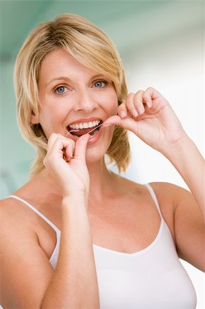 simsearch:400-04043357,k - Woman flossing teeth Photographie de stock - Aubaine LD & Abonnement, Code: 400-04043403