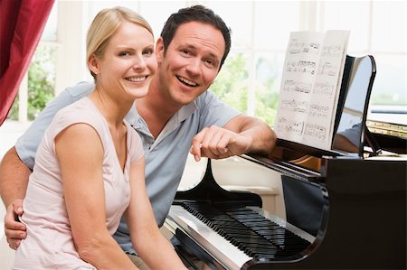piano à queue - Couple sitting at piano smiling Photographie de stock - Aubaine LD & Abonnement, Code: 400-04043587