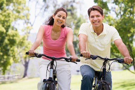simsearch:400-04402106,k - Couple on bikes outdoors smiling Fotografie stock - Microstock e Abbonamento, Codice: 400-04043601