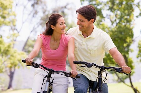 simsearch:400-04402106,k - Couple on bikes outdoors smiling Fotografie stock - Microstock e Abbonamento, Codice: 400-04043602