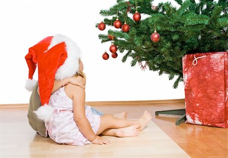 simsearch:400-05008640,k - Kids sitting in front of the christmas tree hugging - isolated Photographie de stock - Aubaine LD & Abonnement, Code: 400-04043709