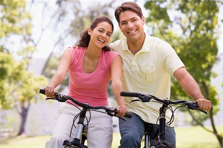 simsearch:400-04402106,k - Couple on bikes outdoors smiling Fotografie stock - Microstock e Abbonamento, Codice: 400-04043717