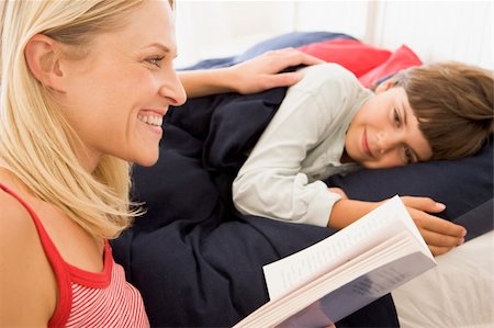 Woman reading book to young boy in bed smiling Stock Photo - Budget Royalty-Free & Subscription, Code: 400-04043787