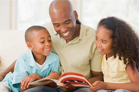 Man and two children sitting in living room reading book and smi Stock Photo - Budget Royalty-Free & Subscription, Code: 400-04043799