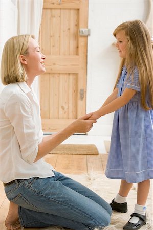 Woman in front hallway holding young girl's hands and smiling Stock Photo - Budget Royalty-Free & Subscription, Code: 400-04043992