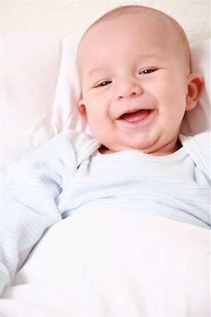 simsearch:400-04161658,k - Portrait of cute newborn laughing in bed Fotografie stock - Microstock e Abbonamento, Codice: 400-04055596