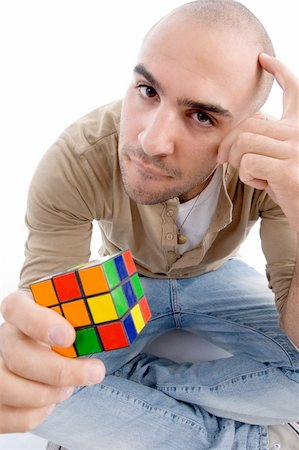 confused man holding puzzle cube with white background Stock Photo - Budget Royalty-Free & Subscription, Code: 400-04055923