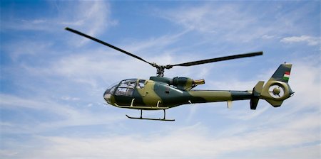 simsearch:400-05888607,k - Flying helicopter on blue sky Foto de stock - Royalty-Free Super Valor e Assinatura, Número: 400-04057215