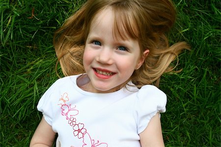 A beautiful four year old child laying in the grass Foto de stock - Royalty-Free Super Valor e Assinatura, Número: 400-04057454