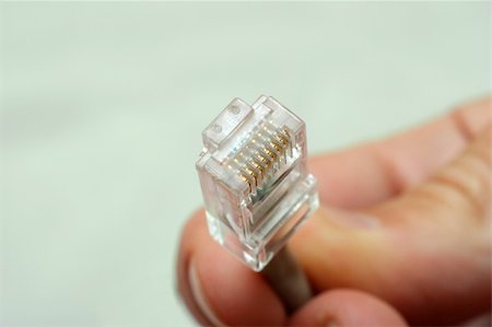 simsearch:625-00898472,k - A hand holding the terminated end of a UTP Ethernet network cable Photographie de stock - Aubaine LD & Abonnement, Code: 400-04059309