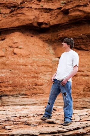 teenager standing on a rock in the mountains of wyoming. Muddy shoes, holes in jeans, hands in pocket. Stock Photo - Budget Royalty-Free & Subscription, Code: 400-04059432