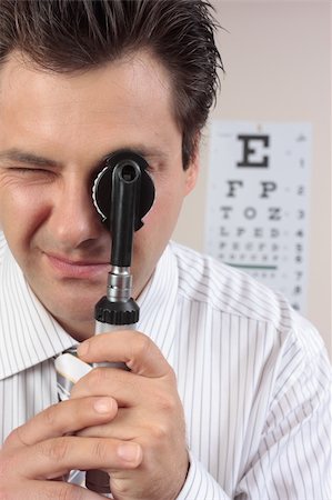 simsearch:400-07630065,k - Eye doctor looking through an opthalmoscope. Foto de stock - Super Valor sin royalties y Suscripción, Código: 400-04059799