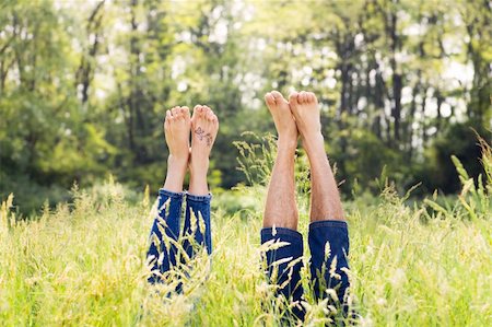 simsearch:400-04059847,k - Couple lying in grass stretching their legs up Stockbilder - Microstock & Abonnement, Bildnummer: 400-04059848