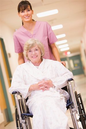 A Nurse Pushing A Senior Woman In A Wheelchair Down A Hospital C Foto de stock - Super Valor sin royalties y Suscripción, Código: 400-04050776