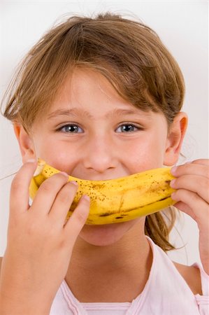 little girl eating banana and looking at the camera Stock Photo - Budget Royalty-Free & Subscription, Code: 400-04051192