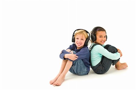 Studio shot of two children, one a blond boy the other a mixed race girl, listening to music on headphones. Isolated studio shot on a white background with a drop shadow for depth. Stock Photo - Budget Royalty-Free & Subscription, Code: 400-04051638