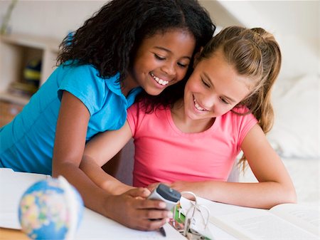 Young Girls Distracted From Their Homework, Playing With A Cellp Stock Photo - Budget Royalty-Free & Subscription, Code: 400-04051708