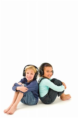 Studio shot of two children, one a blond boy the other a mixed race girl, listening to music on headphones. Isolated studio shot on a white background with a drop shadow for depth. Stock Photo - Budget Royalty-Free & Subscription, Code: 400-04051789