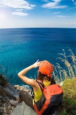 simsearch:400-07176526,k - young woman sitting on top of a cliff and looking up to the sky Stock Photo - Budget Royalty-Free & Subscription, Code: 400-04051994