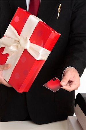 Man makes a christmas or other special occasion purchase with a gift card or credit debit card.  Focus to hand, shallof dof. Stock Photo - Budget Royalty-Free & Subscription, Code: 400-04052090