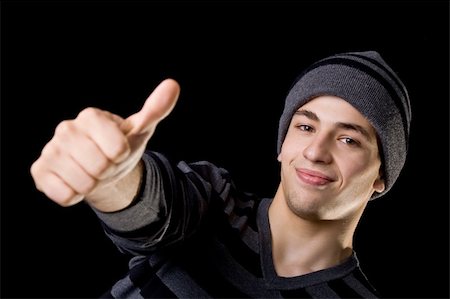 simsearch:400-04643781,k - Handsome young man giving thumbs up, on winter clothes. Isolated on black. Focus on face. Stock Photo - Budget Royalty-Free & Subscription, Code: 400-04052727