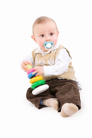 The toddler boy plays developing game. Color pyramidion. Photographie de stock - Aubaine LD & Abonnement, Code: 400-04053283