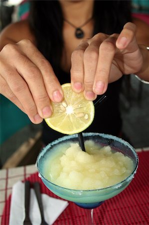 squeeze lemon - woman squeezing lemon into a frozen margarita Stock Photo - Budget Royalty-Free & Subscription, Code: 400-04065874