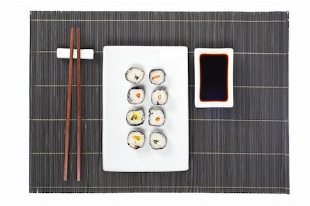 simsearch:400-08072780,k - Sushi on the white plate with soy sauce and chopsticks on bamboo mat Photographie de stock - Aubaine LD & Abonnement, Code: 400-04065990