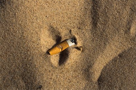 Cigarette butt in sand. Litter on the beach Stock Photo - Budget Royalty-Free & Subscription, Code: 400-04067747