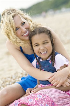 A beautiful blond haired blue eyed young woman having fun with a mixed race young girl at the beach Stock Photo - Budget Royalty-Free & Subscription, Code: 400-04068041