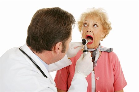 simsearch:400-04117274,k - Senior woman opening her mouth for the doctor to look inside.  Isolated on white background. Photographie de stock - Aubaine LD & Abonnement, Code: 400-04068311