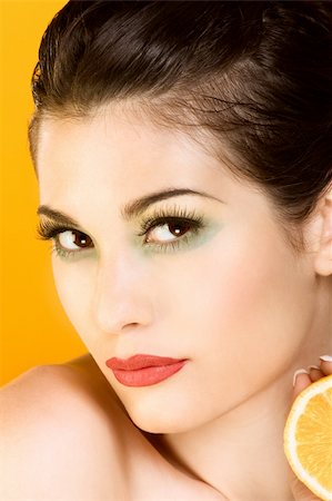 Gorgeous young woman wearing colorful make-up and holding half of lemon Stock Photo - Budget Royalty-Free & Subscription, Code: 400-04068329