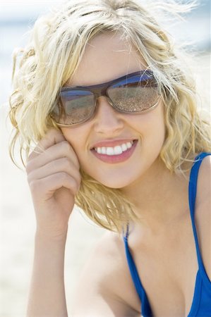 simsearch:400-04310598,k - A beautiful blond haired model wearing sunglasses and with a gorgeous smile shot in close up at the beach and illuminated with natural light Stock Photo - Budget Royalty-Free & Subscription, Code: 400-04068731